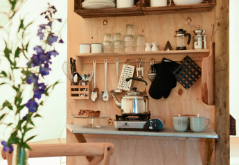 Küchenbereich im Safari-Zelt Smûk Grutte Bell Tent bei Smûk Recreatie in den Niederlanden mit Geschirr.