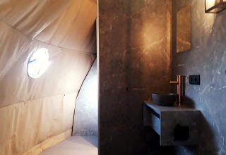 Interior view of the Dome lodge at Costa Kabrita in the Netherlands showing a modern bathroom and tent wall.