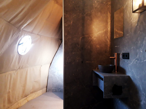 Vista interior del lodge Dome en Costa Kabrita, Países Bajos, con baño moderno y pared de tienda de campaña.