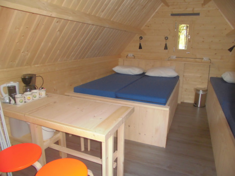 Interior del Kabouterhuisje en Vakantiepark 't Urkerbos, Países Bajos, con decoración de madera y camas.
