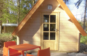 Kleine Holzhütte mit orangefarbenen Stühlen und Tisch, gelegen im Waldpark Vakantiepark 't Urkerbos, Niederlande.