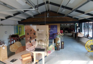 Ausstellungsraum mit landwirtschaftlichen Wagen und Infotafeln im Vakantiepark De Luttenberg, Niederlande.