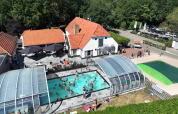 Oversigtsbillede af et fyldt swimmingpoolområde med glastag i ferieparken De Luttenberg, Overijssel.