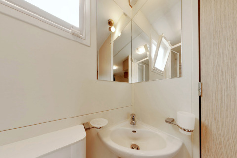 Piccolo bagno nella SunLodge Maple al Camping Bella Italia in Italia con lavandino, specchio e finestra.