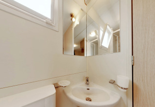 Pequeño baño en SunLodge Maple en Camping Bella Italia, Italia, con lavabo, espejo y ventana.