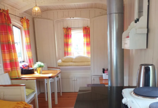 Interior de la tiny house Pipowagen en Buytenplaets Suydersee, Países Bajos, con decoración colorida.