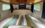 Acogedor dormitorio en la cabaña Kajuitboot en Buytenplaets Suydersee, Países Bajos, con camas gemelas.