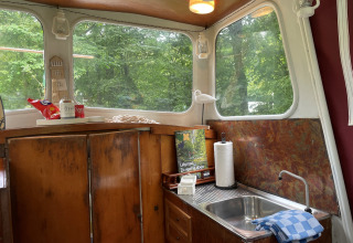 Knusse kitchenette met houten kastjes en grote ramen in een Kajuitboot-lodge, Buytenplaets Suydersee, Nederland.