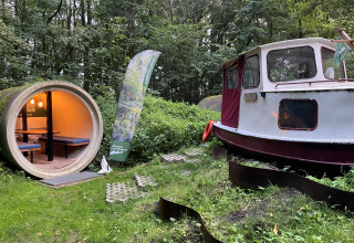 Kajuitboot lodge bij Buytenplaets Suydersee in Nederland met boot en ronde hut in het bos.