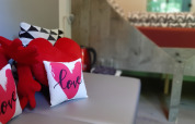 Acogedor interior de la tiny house Pipo Love en Buytenplaets Suydersee, Países Bajos, con cojines de corazón.
