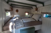 Dormitorio luminoso y acogedor con ventanas en Pipo Maison de Buytenplaets Suydersee en los Países Bajos.