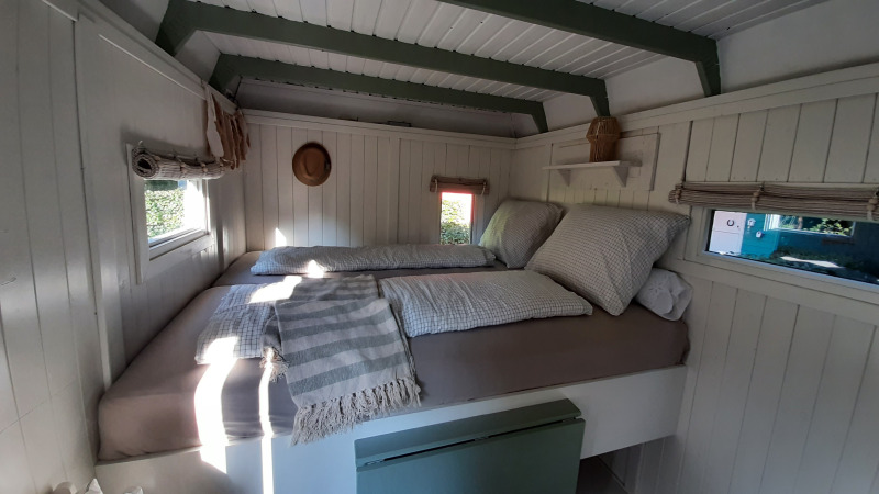 Dormitorio luminoso y acogedor con ventanas en Pipo Maison de Buytenplaets Suydersee en los Países Bajos.