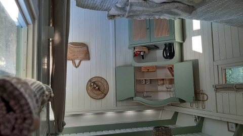 Vista interior de una acogedora cabaña en Pipo Maison, Buytenplaets Suydersee, con armarios rústicos y luz natural.