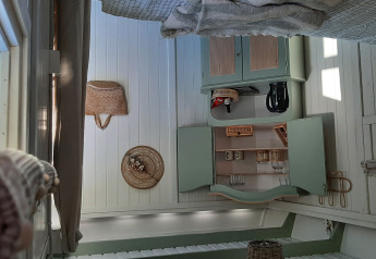 Vue intérieure d’un lodge confortable à Pipo Maison, Buytenplaets Suydersee, avec des placards rustiques et de la lumière naturelle.