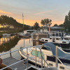 Boats docked at Marina Parcs Amsterdam holiday park in North Holland, Netherlands during sunset.