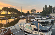 Både ligger fortøjet ved Marina Parcs Amsterdam i Nordholland, Holland, under en smuk solnedgang.