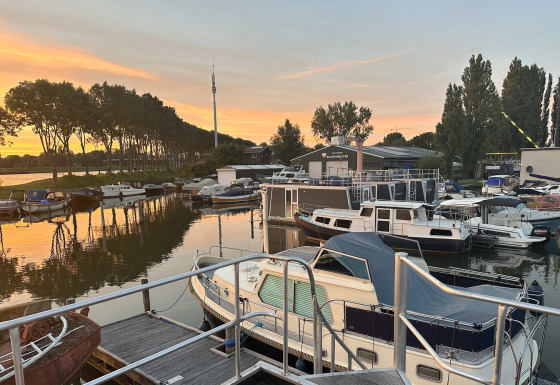 Boten aangemeerd aan het Marina Parcs Amsterdam vakantiepark in Noord-Holland bij zonsondergang.