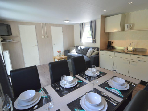 Essbereich und Wohnzimmer im Easy Chalet bei Eurocamping Vessem BV in den Niederlanden, modern eingerichtet.