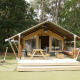 Safari telt lodge med trædæk, bænk, picnicbord og skovbaggrund ideel til afslappet ophold.