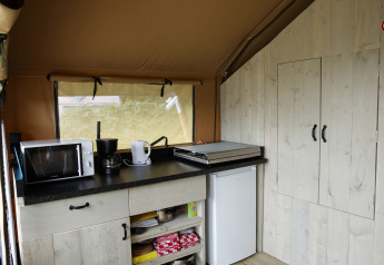 Et moderne tekøkken i Safari-teltet ved Costa Kabrita, Holland, med mikrobølgeovn og kaffemaskine.