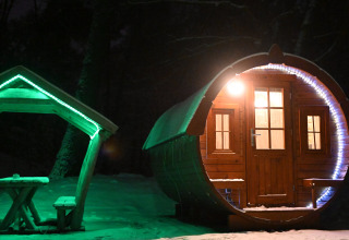 Piccola casa a forma di botte 'Wijnvat' illuminata nella neve di notte, Costa Kabrita nei Paesi Bassi.