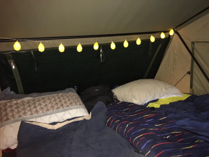 Vista interior de una tienda con luces decorativas y ropa de cama en Treelodge de Costa Kabrita, Países Bajos.