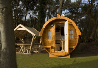 Et rundt træhus kaldet Wijnvat ved Costa Kabrita i Holland, omgivet af skov og picnicområde.