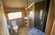 Badkamer in een safaritent met douche, toilet en wastafel bij Camping de Tolbrug in Nederland.