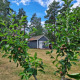Accogliente casa blu a Stuga glamping, Småland Miniglamping, Svezia, con alberi da frutto e cielo azzurro.