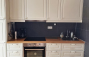 Cocina blanca moderna con encimera de madera, horno y fregadero en un lodge de Stuga Glamping en Suecia.
