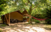 Safari-telt med sanitære faciliteter på Camping Fargogne i Frankrig med terrasse og hængekøje i natur.