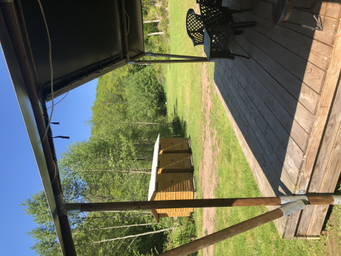 Uitzicht vanaf een safaritent-terras bij Camping Bockenauer Schweiz, met houten vlonder en groene natuur.