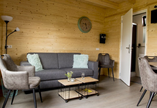Wohnzimmer in einer Holzhütte im Vakantiehuisje hooiberg, Camping Nieuw Romalo, modern eingerichtet.