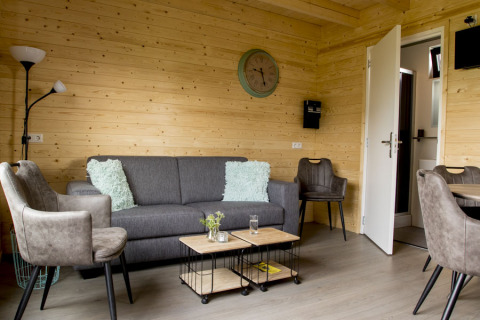 Wohnzimmer in einer Holzhütte im Vakantiehuisje hooiberg, Camping Nieuw Romalo, modern eingerichtet.