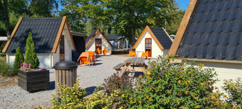Hyggelige A-ramme hytter og have på Kabouterhuisje, Vakantiepark 't Urkerbos, Nederlandene, solskin.