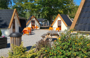 Acogedoras cabañas tipo A en Kabouterhuisje, Vakantiepark 't Urkerbos, Países Bajos, con sillas naranjas.