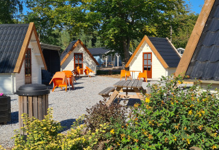 Acogedoras cabañas tipo A en Kabouterhuisje, Vakantiepark 't Urkerbos, Países Bajos, con sillas naranjas.