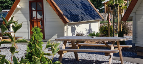 Gezellig tiny house met picknicktafel in de zon bij Vakantiepark 't Urkerbos, Nederland.