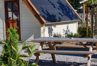 Gezellig tiny house met picknicktafel in de zon bij Vakantiepark 't Urkerbos, Nederland.