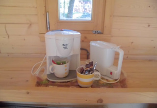 Koffiezet en waterkoker op houten keukenblad in Kabouterhuisje in Vakantiepark 't Urkerbos, Nederland.