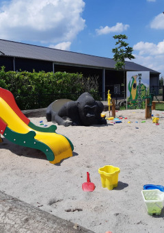 Playground with slide, animal figures, and sand toys at Camping Nieuw Romalo holiday park in Gelderland, Netherlands.