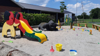 Playground with slide, animal figures, and sand toys at Camping Nieuw Romalo holiday park in Gelderland, Netherlands.
