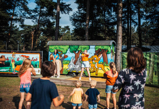 Kinder nehmen an einer Aktivität vor einer bunten Hütte im Eurocamping Vessem, Nordbrabant, Niederlande, teil.