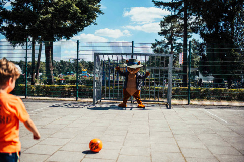 Niño patea un balón hacia una mascota en la portería en Eurocamping Vessem, Brabante Septentrional, Países Bajos.