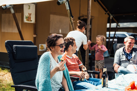 Familie genießt Zeit beim Camping im Eurocamping Vessem BV, Nordbrabant, Niederlande, draußen sitzend.