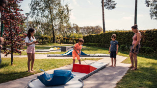 Famille jouant au mini-golf dans le parc de vacances Eurocamping Vessem BV en North-Brabant, Pays-Bas.