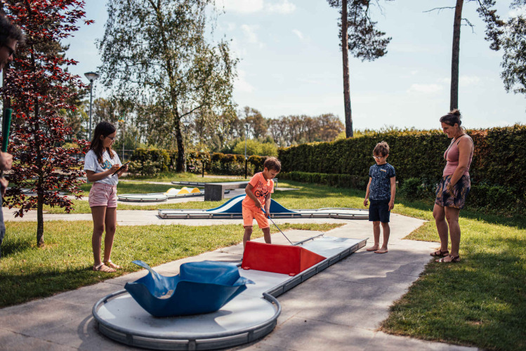 Famiglia che si diverte a giocare a minigolf al parco vacanze Eurocamping Vessem BV nel North-Brabant, Paesi Bassi.