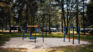 Parque infantil entre árboles en Eurocamping Vessem BV, parque vacacional familiar en Brabante Septentrional.
