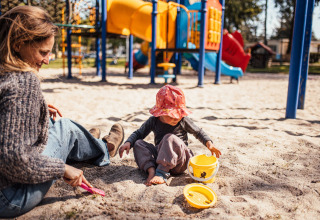 Ein Erwachsener und ein Kind spielen im Sand auf einem Spielplatz im Eurocamping Vessem BV in Nordbrabant, Niederlande.