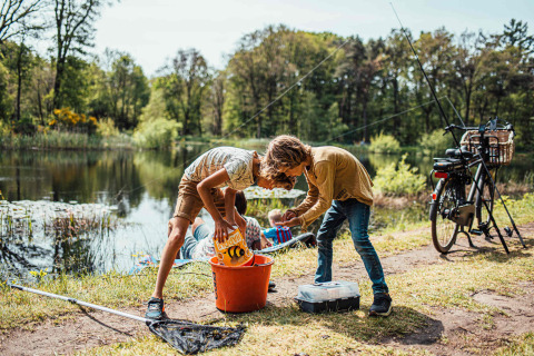 Deux enfants pêchent près d’un lac à Eurocamping Vessem BV, un parc de vacances dans le Brabant-Septentrional, Pays-Bas.